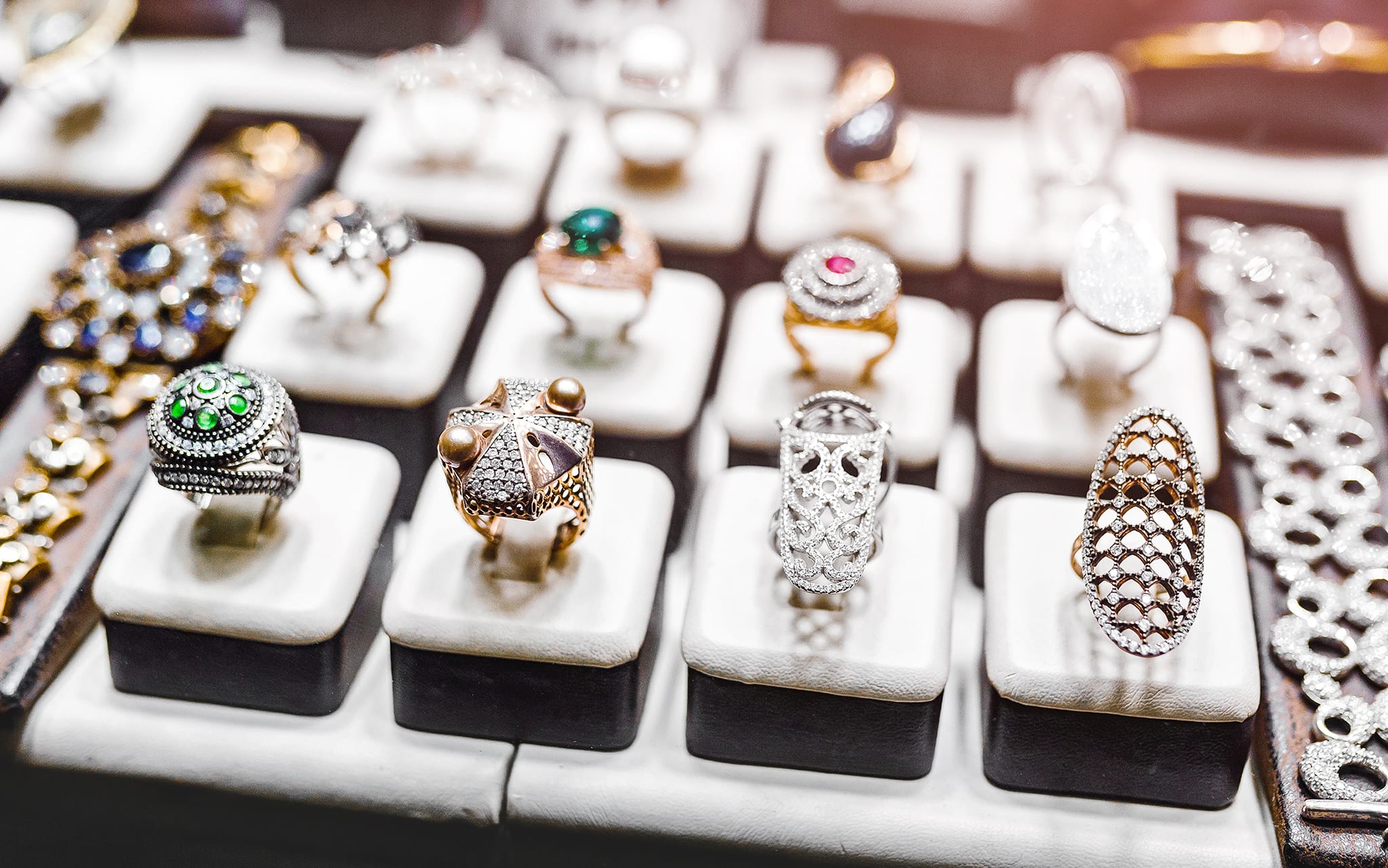 Various Golden rings with precious gems in jewelry shop, window close-up